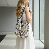 Woman in beige dress carrying large boho canvas shoulder bag with black geometric print