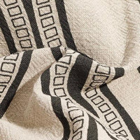 Beige textured fabric with black geometric striped square pattern, modern textile design