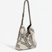 Beige canvas shoulder bag with black geometric chain pattern and adjustable strap