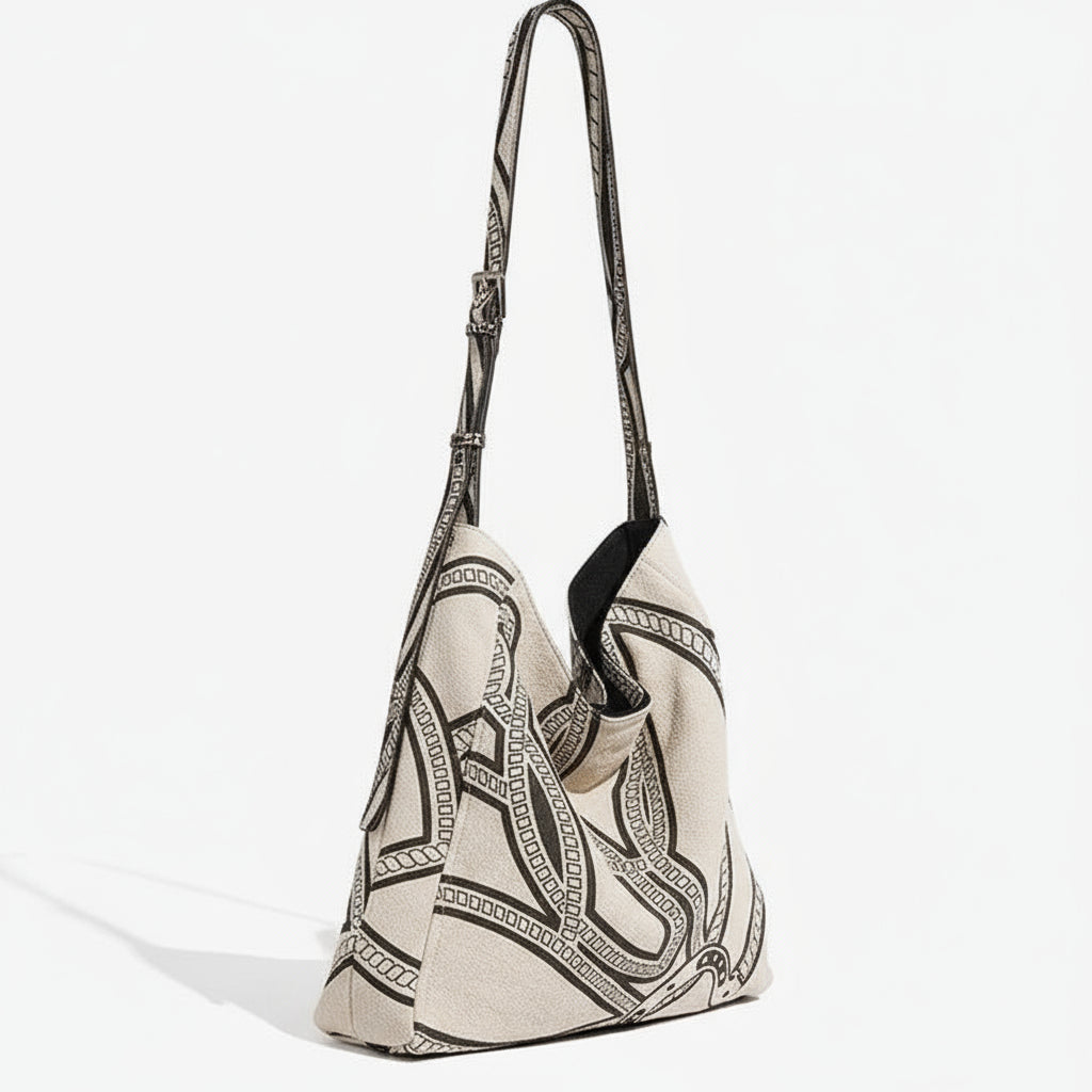 Beige canvas shoulder bag with black geometric chain pattern and adjustable strap