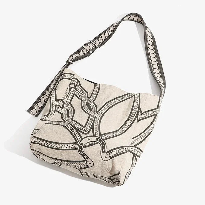Canvas shoulder bag with black abstract line pattern on off-white background