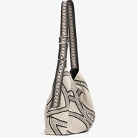 Beige canvas shoulder bag with black geometric pattern and adjustable strap