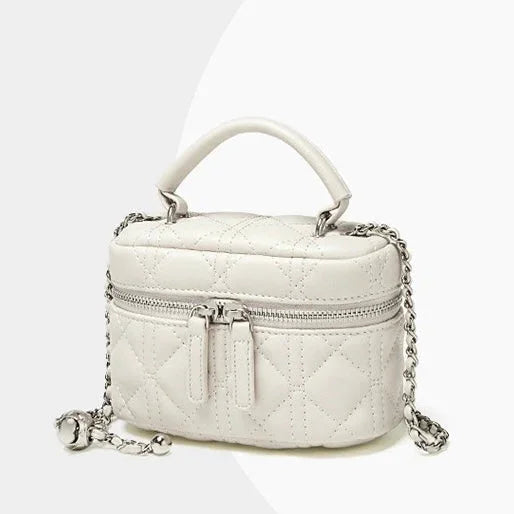 Quilted white leather mini handbag with top handle, zipper, and silver chain strap