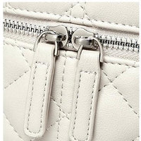 Close-up of white quilted leather bag with double zipper pull and silver hardware