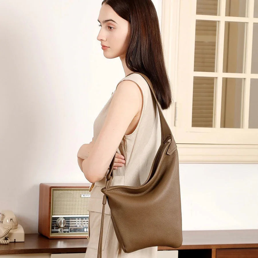 Woman in beige dress with brown leather shoulder bag in vintage room with radio