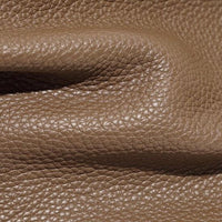 Close-up of textured brown pebbled leather material with natural fold and grain detail