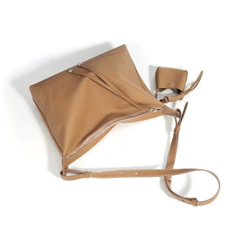 Tan leather crossbody bag with zipper and small matching pouch on white background