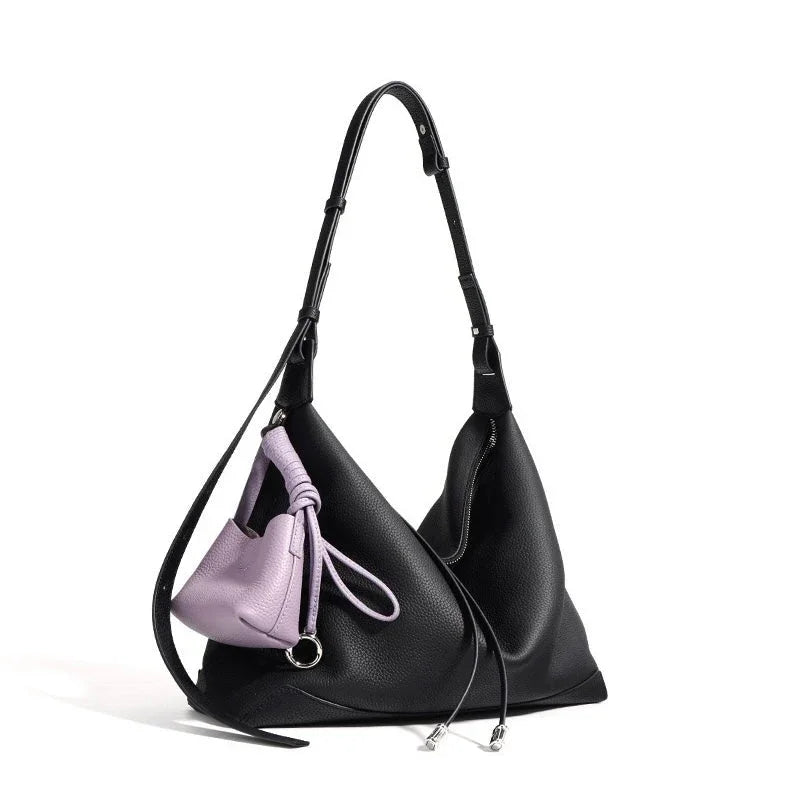 Black leather shoulder bag with adjustable strap and attached small lavender pouch