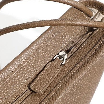 Textured brown leather handbag with zipper pocket and double handles