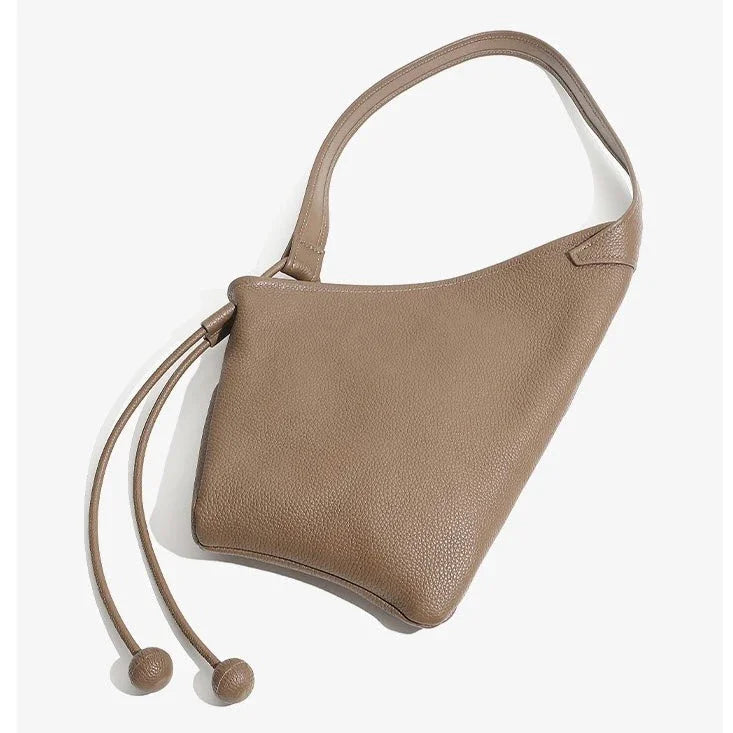 Taupe leather shoulder bag with drawstring closure on a white background