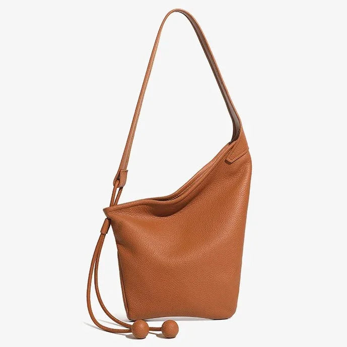 Brown leather bucket bag with drawstring and minimalist design on white background