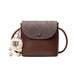 Brown crossbody purse with gray flap and plush bear keychain accessory