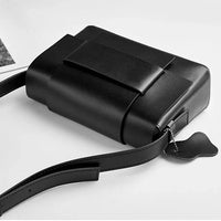 Minimalist black leather crossbody bag with wide strap on white background