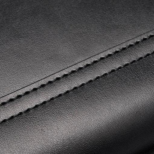 Close-up of black leather material with detailed stitching seam
