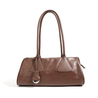 Brown leather shoulder bag with double handles and silver ring detail on white background