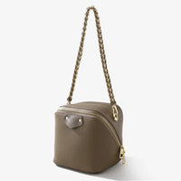 Taupe leather box bag with gold chain strap and zipper, stylish cube purse on white background