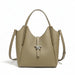 Taupe leather tote handbag with top handle, shoulder strap, and silver clasp on white background