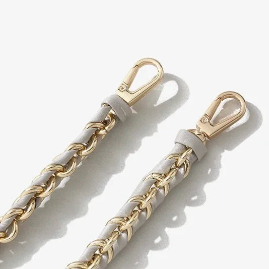 Gold chain purse straps with white leather weaving and metal clasps on white background