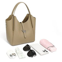 Taupe leather tote bag with sunglasses, smartphone, lotion, deodorant, and pink umbrella