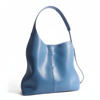 Minimalist blue leather shoulder bag with a wide strap on a white background