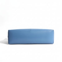 Bottom view of a rectangular blue leather handbag on a white background