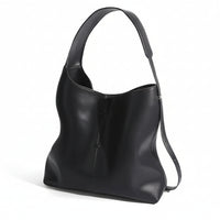 Black leather shoulder bag with wide strap and minimalist design on white background