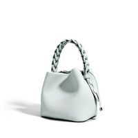 Light gray textured leather handbag with braided handle on white background