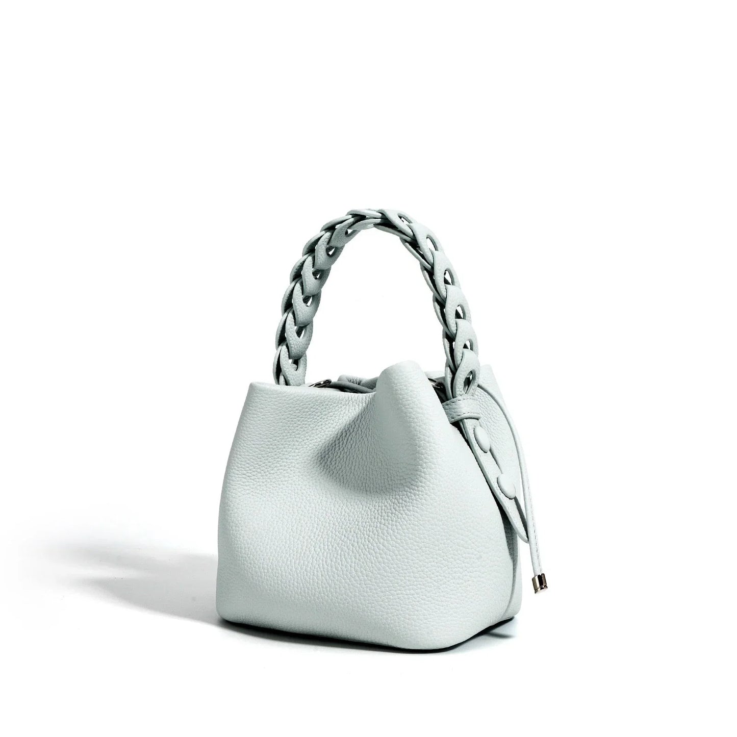 Light gray textured leather handbag with braided handle on white background