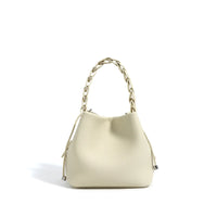 Cream leather bucket bag with braided handle and silver accents on a white background