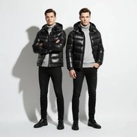 Two men wearing black puffer jackets and black pants on a white background