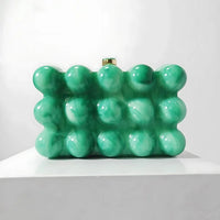 Green bubble textured clutch purse with marble effect on white display stand