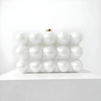 White pearl bubble clutch purse with gold clasp on white display pedestal