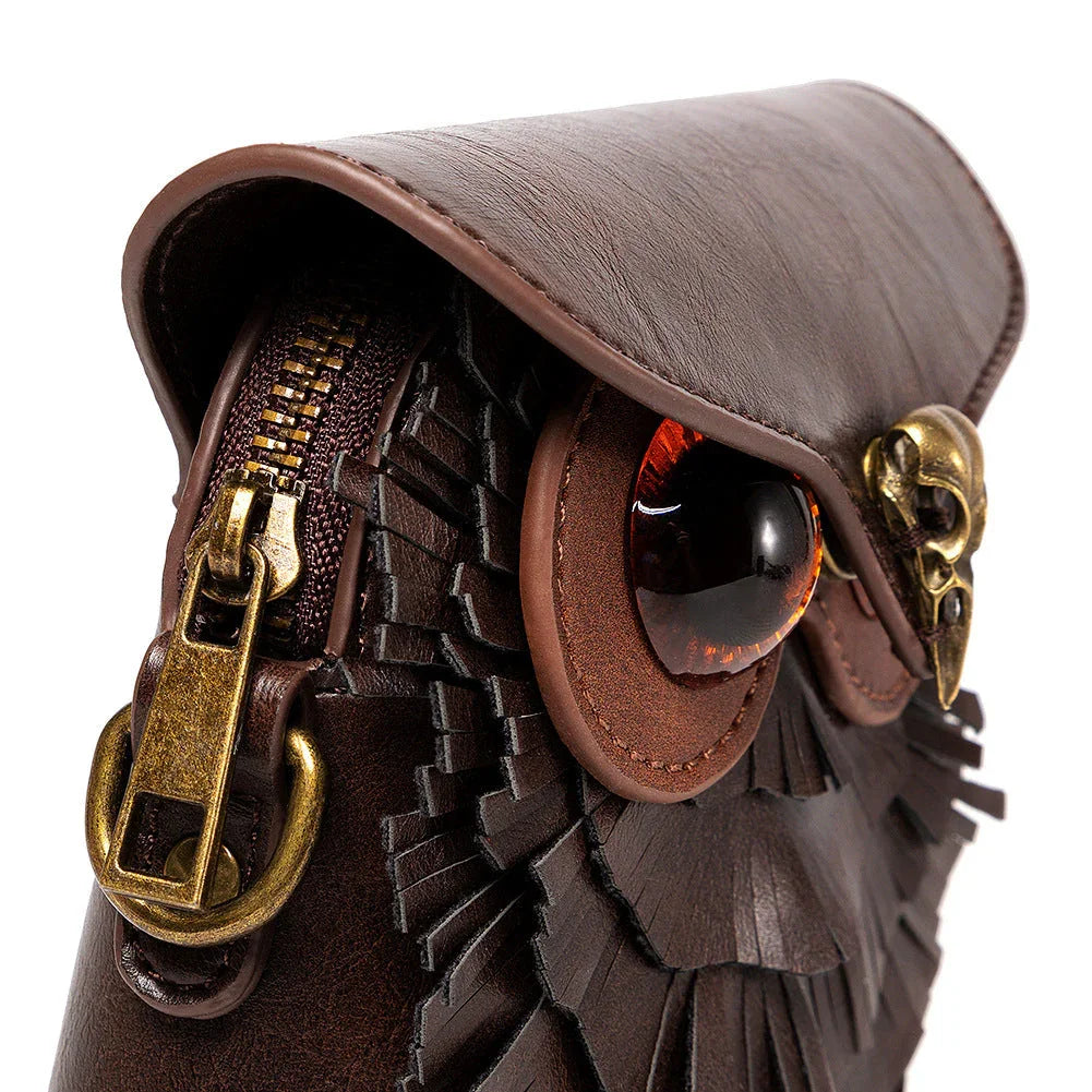 Brown leather owl-shaped purse with large eyes, brass skull detail, and zipper