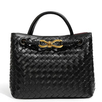 Black woven leather handbag with gold hardware and double handles on white background