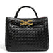 Black woven leather handbag with gold hardware and double handles on white background