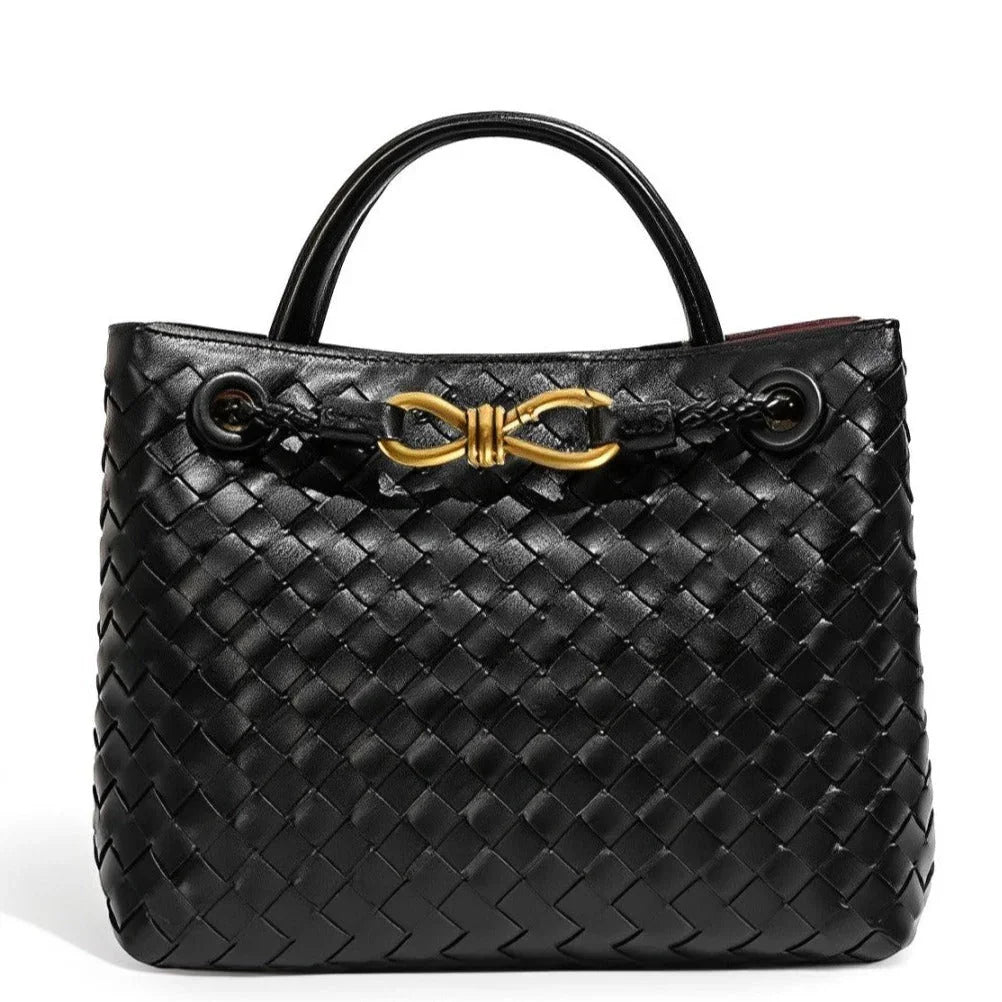 Black woven leather handbag with gold hardware and double handles on white background