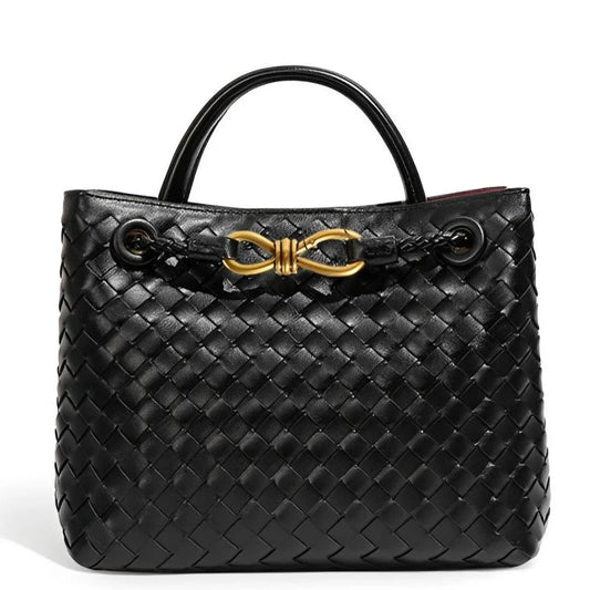 Black woven leather handbag with gold hardware and double handles on white background