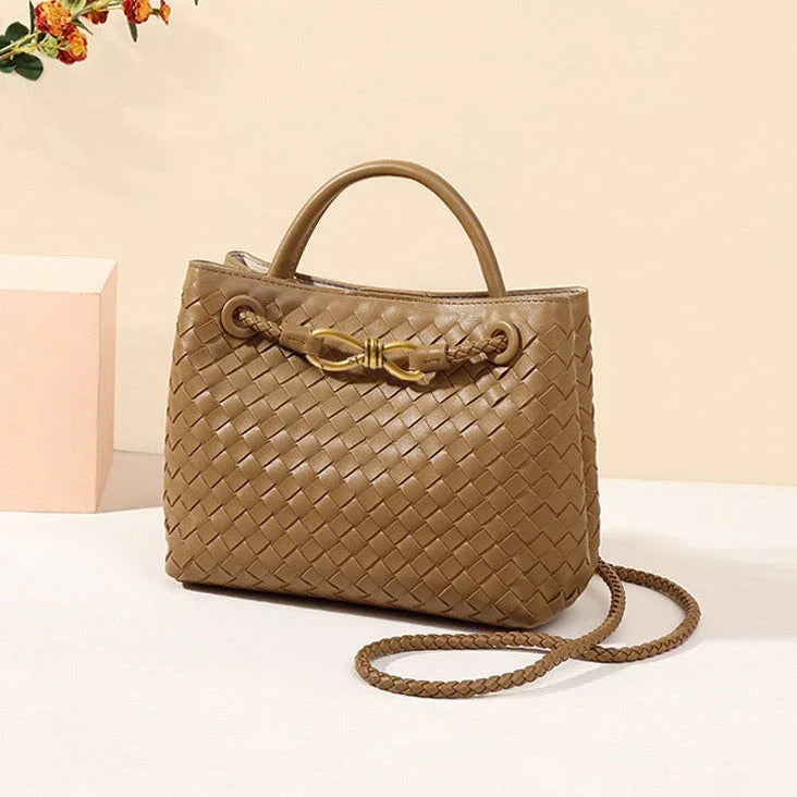 Brown woven leather handbag with gold clasp and braided strap on beige background