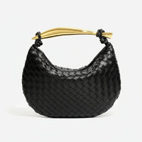 Black woven leather handbag with gold curved handle on white background