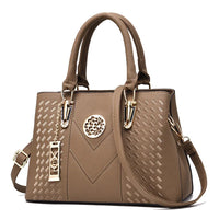 Elegant brown leather handbag with gold accents and textured geometric pattern