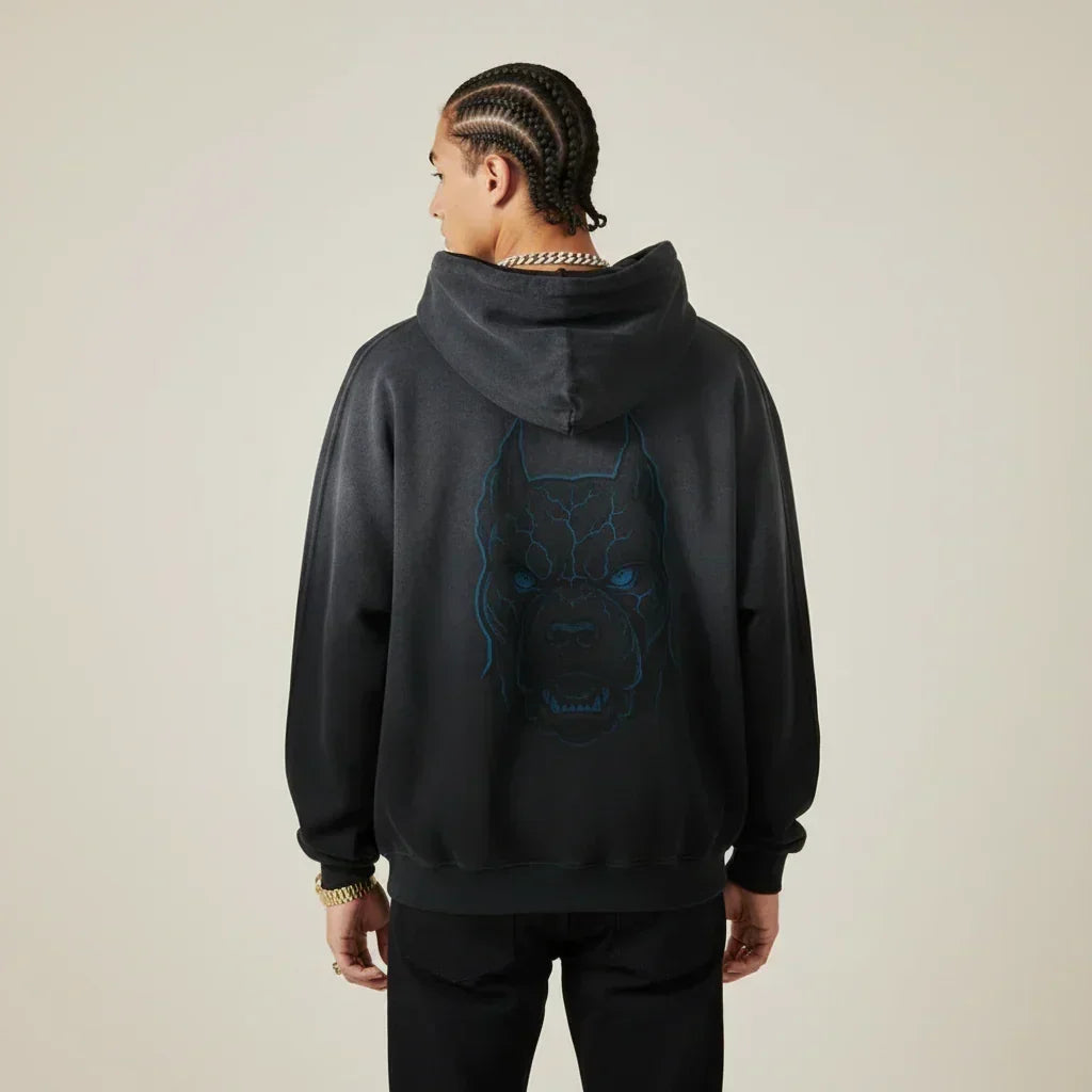 Person wearing a black hoodie with a Pitbull dog graphic on the back against a beige background | Rebooters