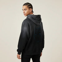 Person wearing a black hoodie with a Pitbull dog graphic on the back against a beige background | Rebooters