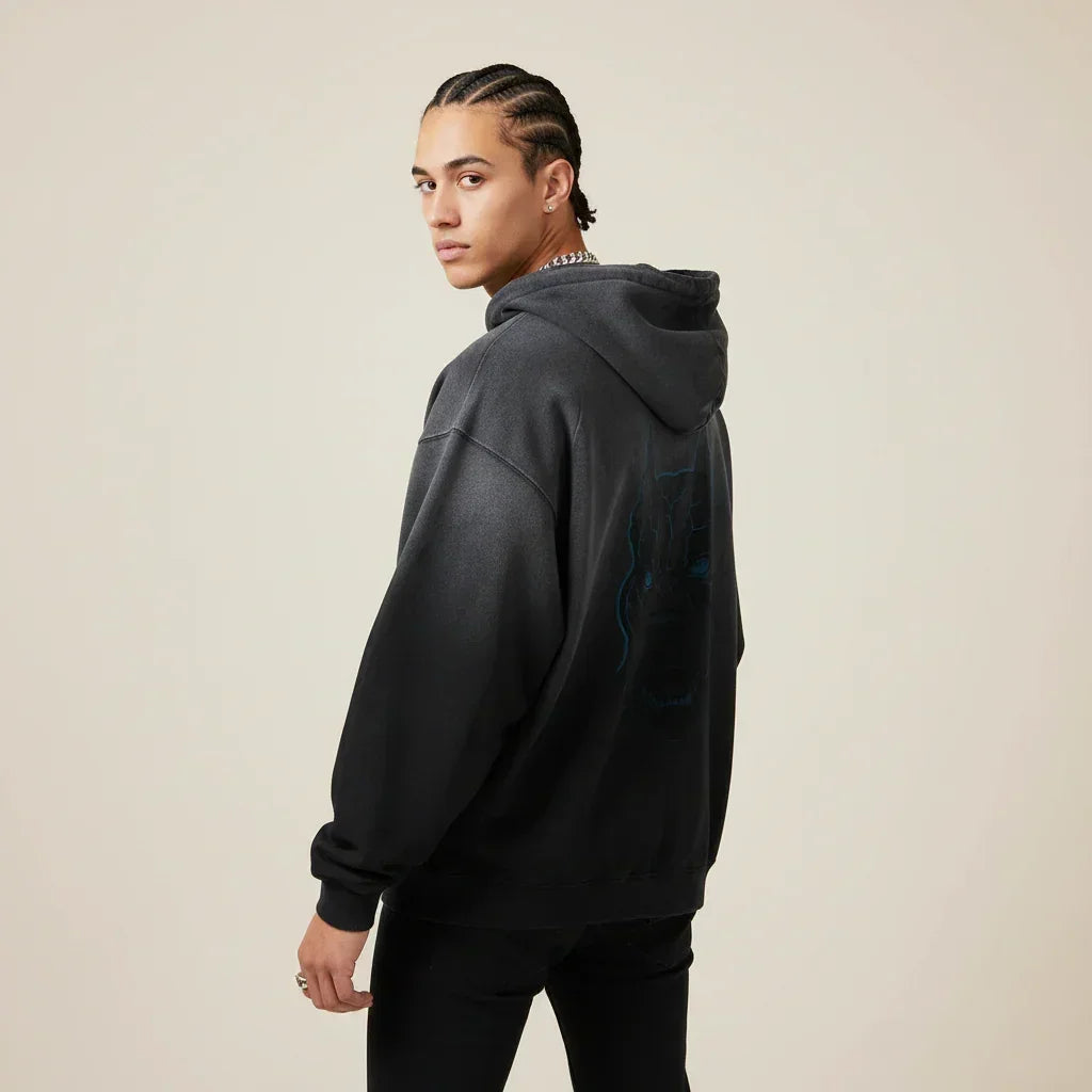 Person wearing a black hoodie with a Pitbull dog graphic on the back against a beige background | Rebooters