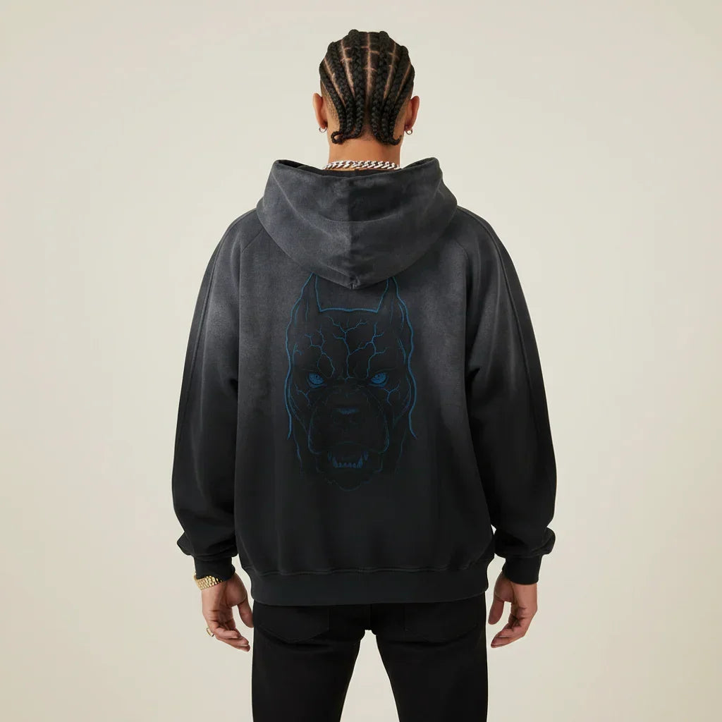 Person wearing a black hoodie with a Pitbull dog graphic on the back against a beige background | Rebooters