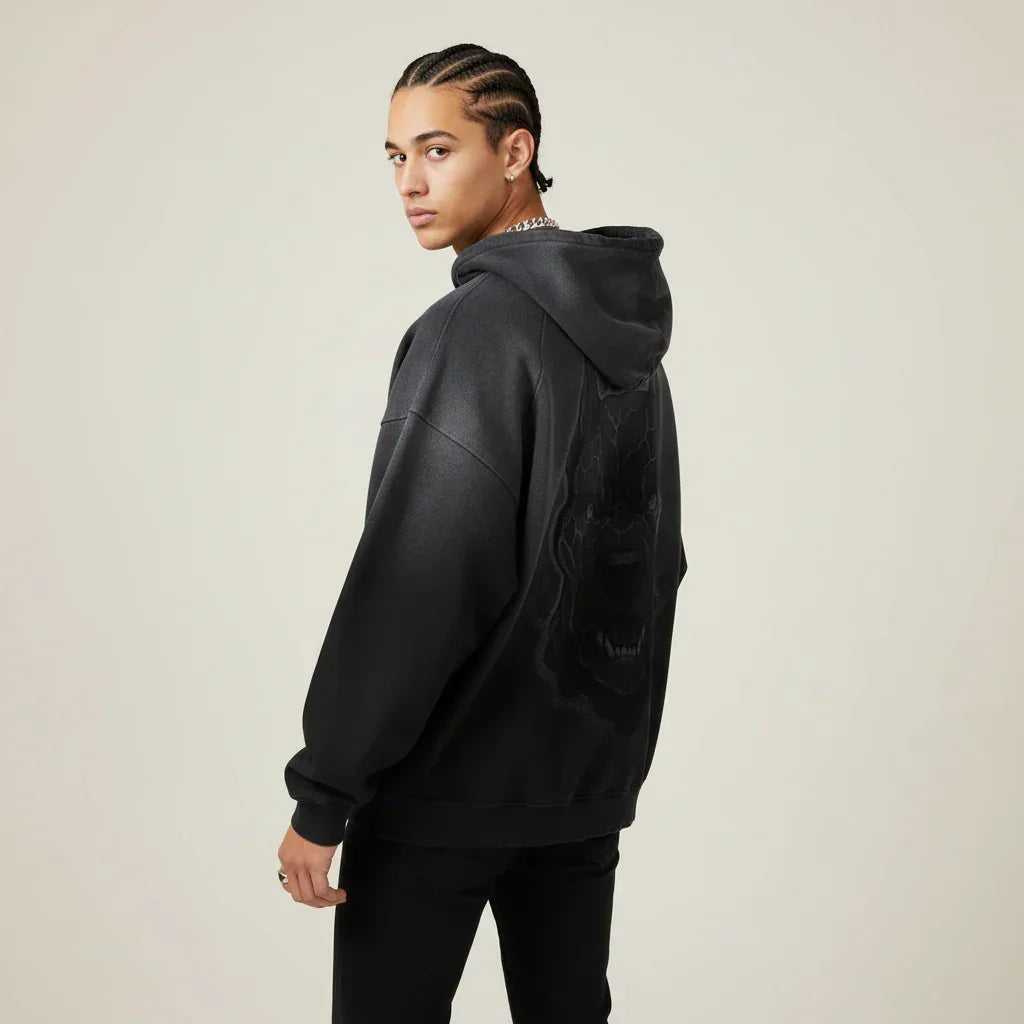 Person wearing a black hoodie with a Pitbull dog graphic on the back against a plain background | Rebooters