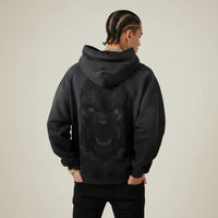 Person wearing a black hoodie with a Pitbull dog graphic on the back against a plain background | Rebooters