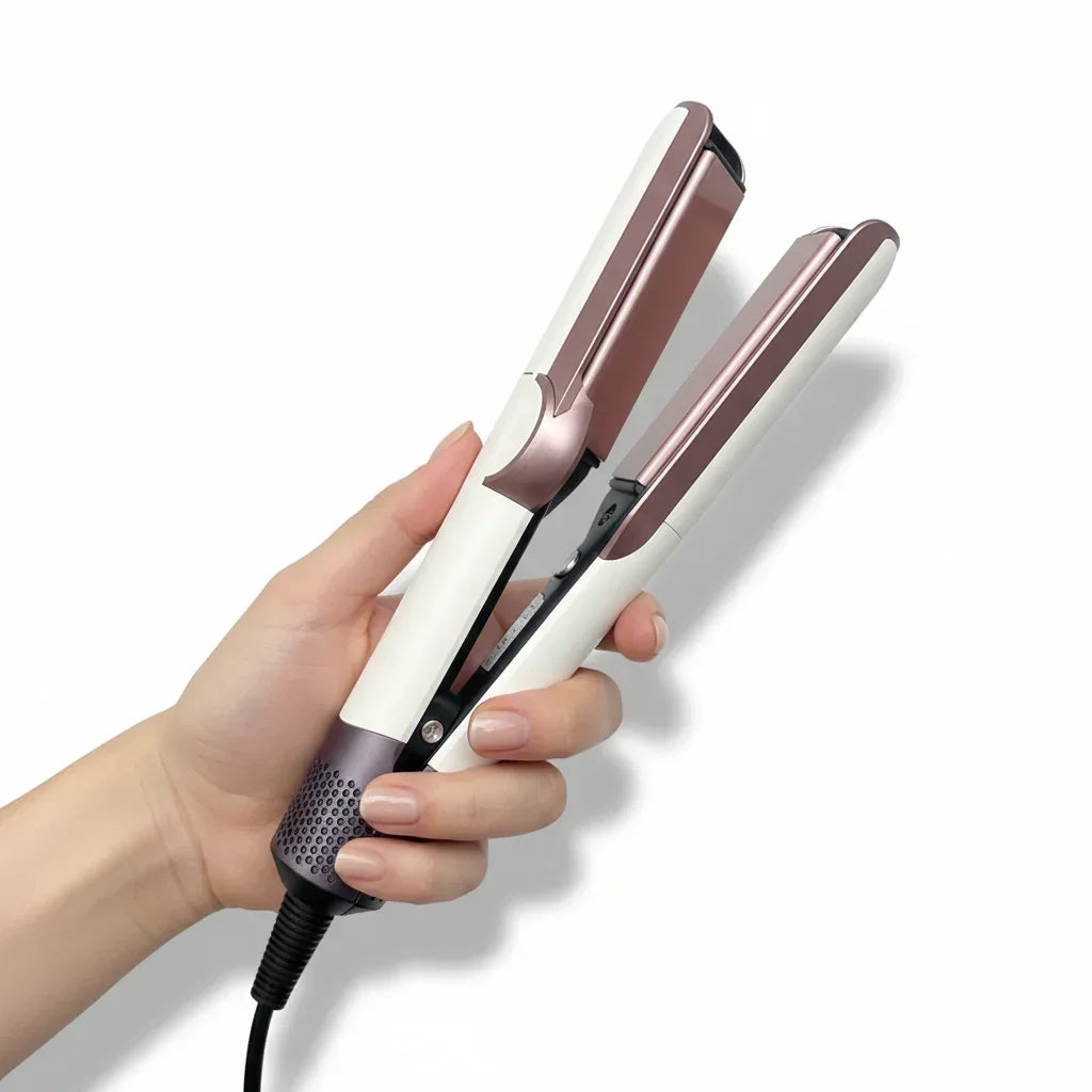 Hand holding a rose gold and white hair straightener on a white background