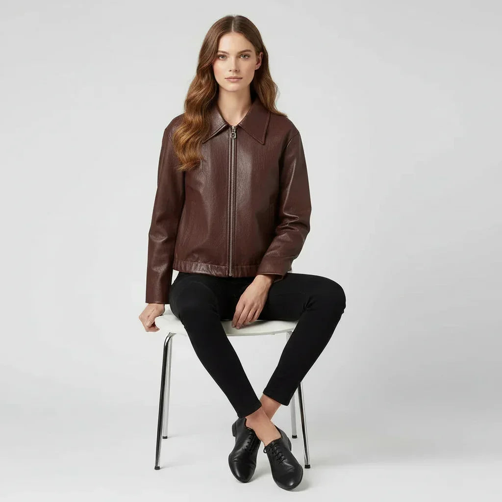 Woman wearing a brown leather jacket and black pants on a white background