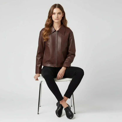 Woman wearing a brown leather jacket and black pants on a white background