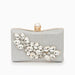 Silver clutch purse with crystal embellishments and pearl clasp on white background